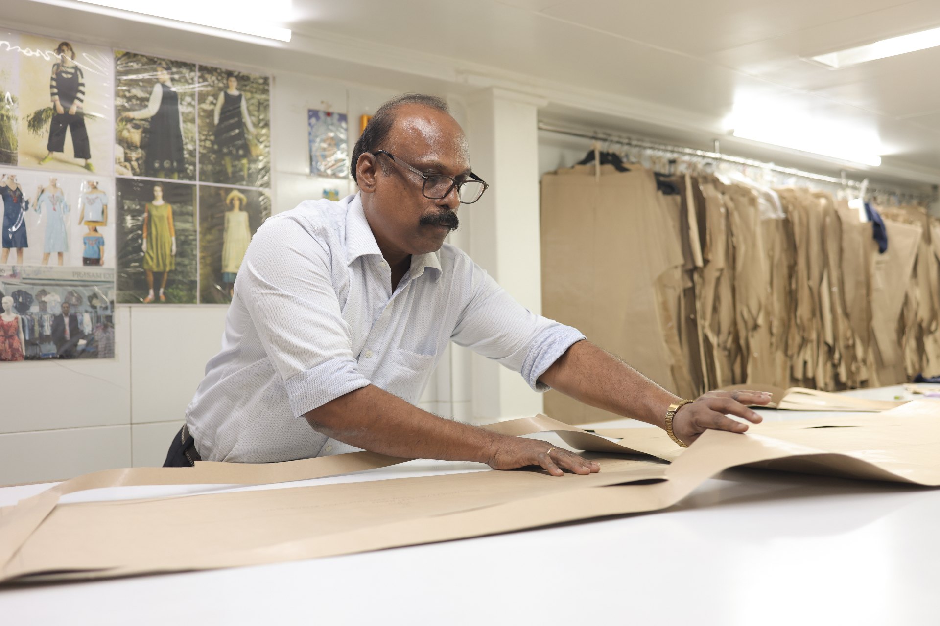 Pattern master laying out sample pieces on fabric